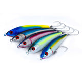 Four metallic fishing lures with treble hooks, arranged diagonally on a white background. The lures have iridescent bodies with blue, yellow, silver, and pink tones, and detailed red eyes.