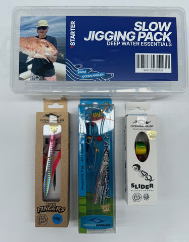 Ocean Angler Slow Jigging Pack starter kit containing a clear plastic storage case with a blue label and three individual packages of fishing lures: a pink and silver jig, a blue and silver spinnerbait, and a white Slider soft plastic lure.